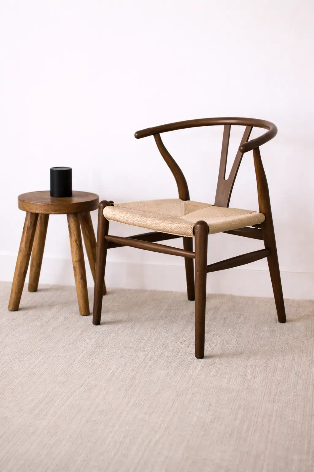 Front view of mid-century wooden wishbone chair UK featuring curved walnut frame and hand-woven rattan seat.