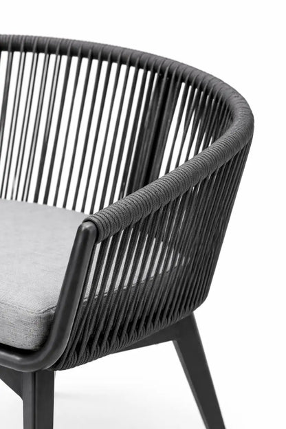 Black wicker chair with a gray cushion on a white background