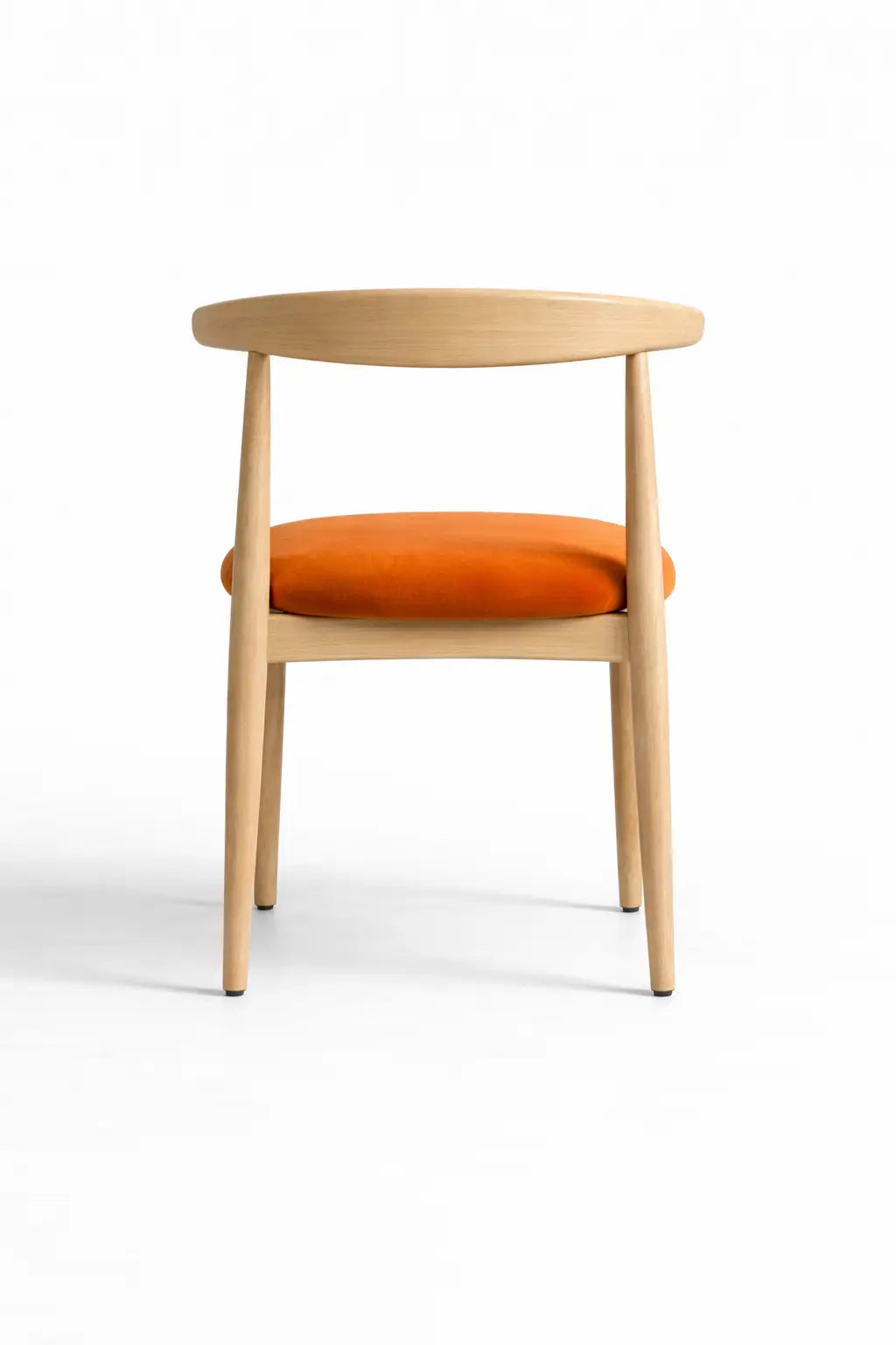 Back view of minimalist Scandinavian dining chair featuring natural oak frame and upholstered orange velvet seat.