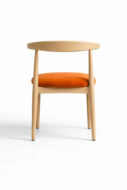 Back view of minimalist Scandinavian dining chair featuring natural oak frame and upholstered orange velvet seat.