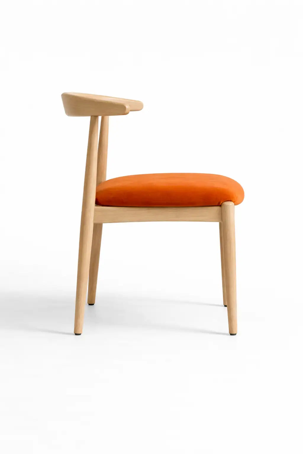 Side view of modern oak dining chair with ergonomic curved backrest and burnt orange velvet seat cushion.