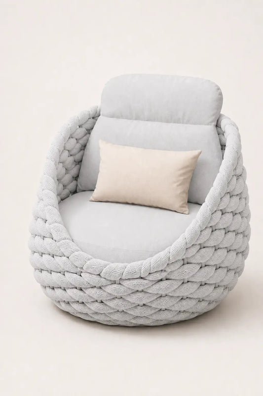 Light gray braided chair with a cushion on a white background