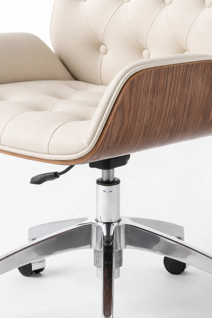 Close-up of cream button-tufted backrest and seat with a curved walnut side panel on an executive office lounge chair