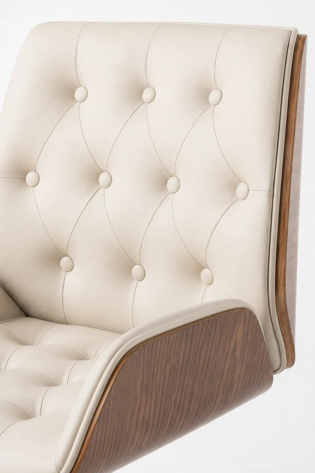 Close-up of cream button-tufted backrest and seat with a curved walnut side panel on an executive office lounge chair