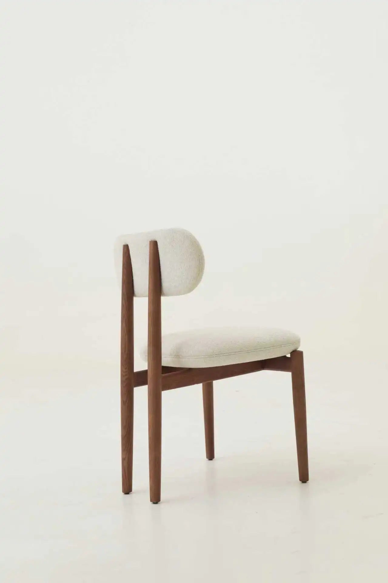 Modern chair with wooden frame and white cushion on a light background