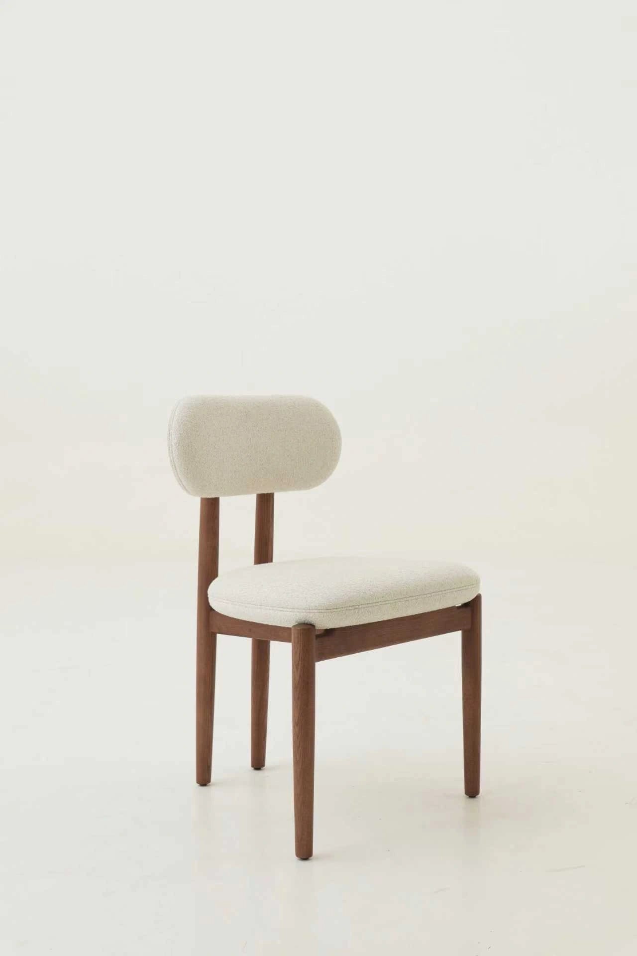 Chair with wooden frame and white cushion on a light background