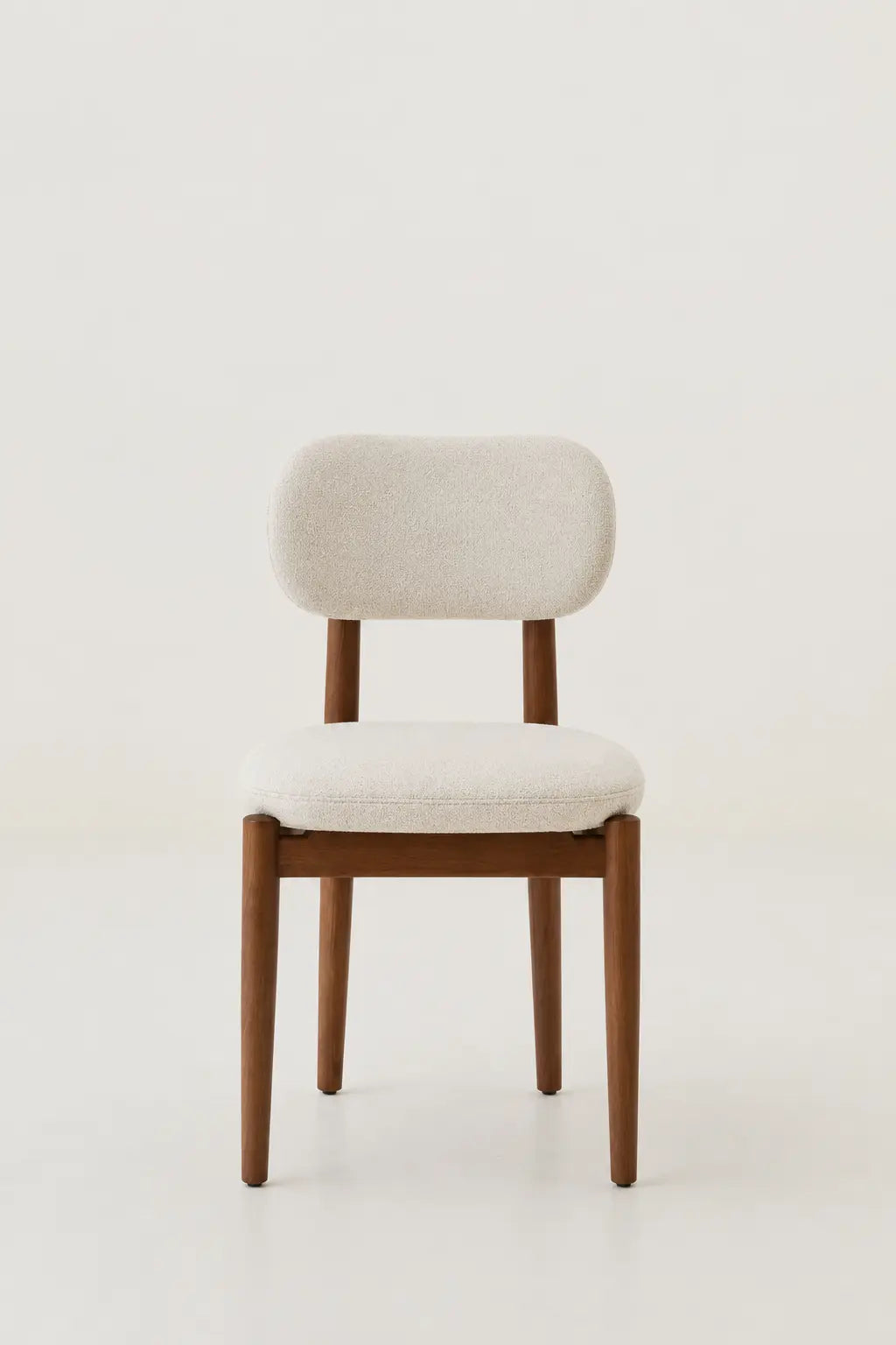 Chair with wooden frame and white cushion on a light background