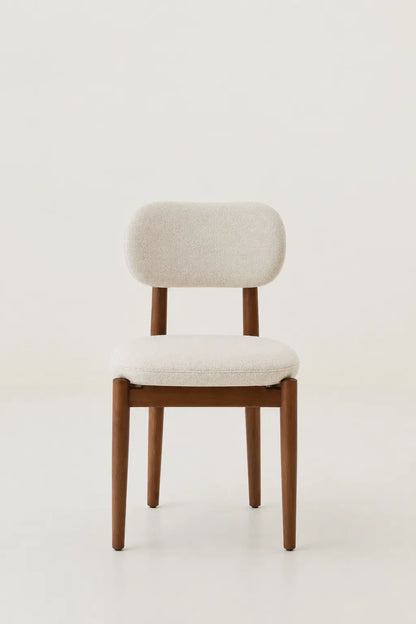 Chair with wooden frame and white cushion on a light background