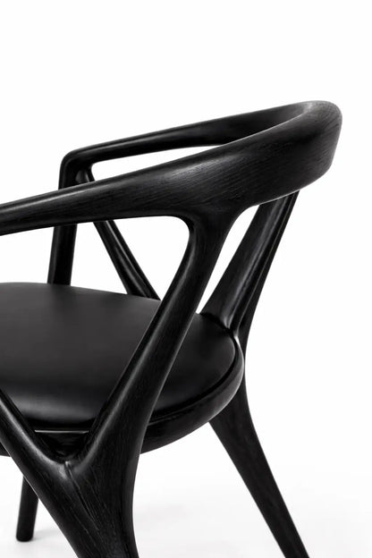 mid century modern chair UK angled view showcasing black wood structure and fabric seat