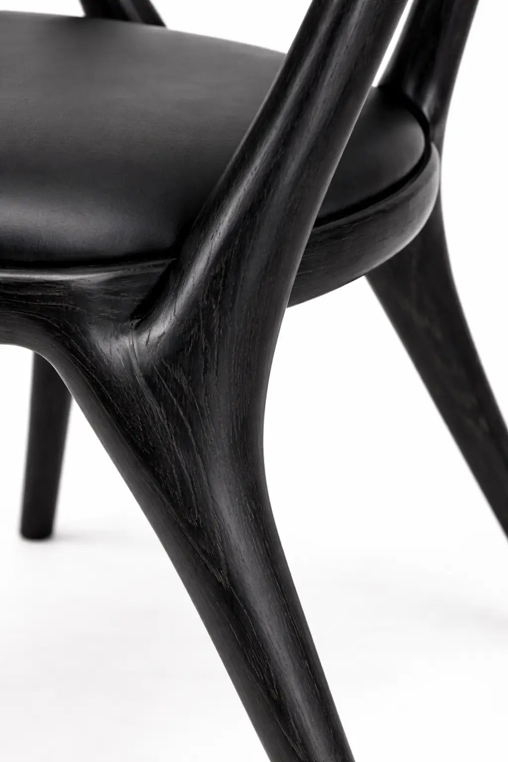 Detail of wooden dining chair leg and joinery showing craftsmanship and smooth finish