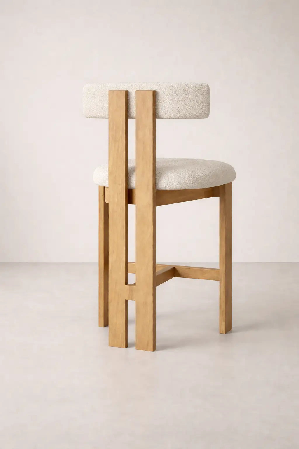 Feltham bar stool UK in solid ash wood with bouclé seat, modern wooden bar stool back view on neutral studio background.
