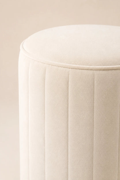 Close-up of a beige cushioned stool on a beige background