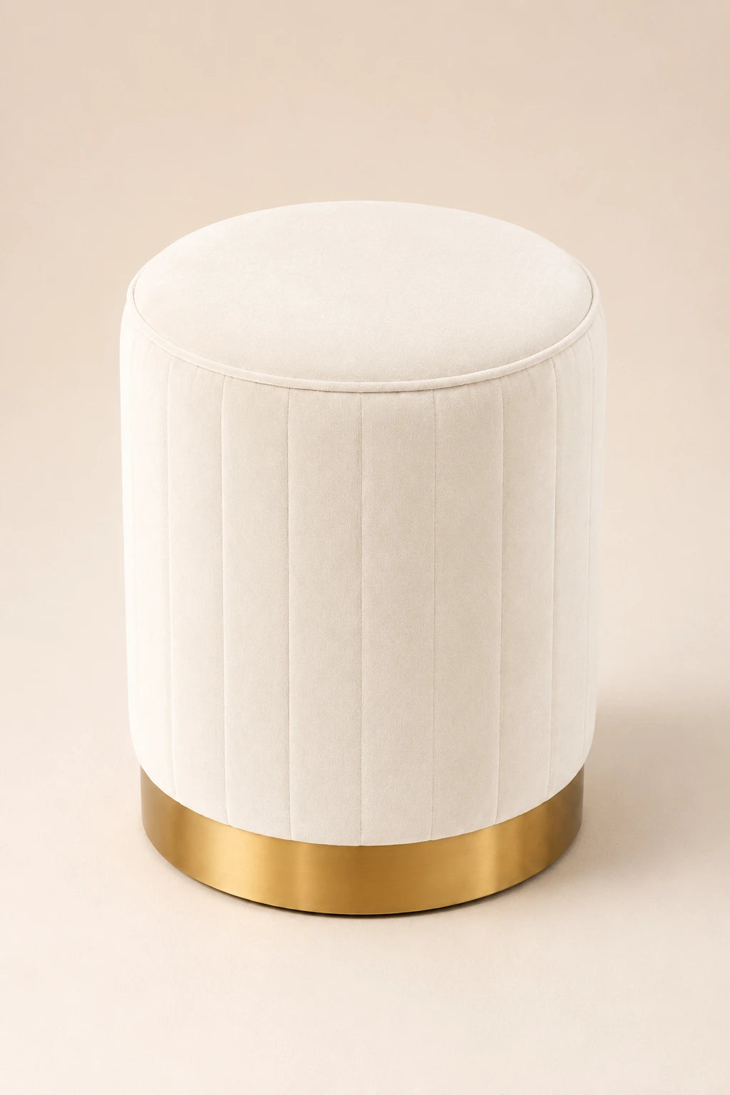 White ottoman with a gold base on a beige background