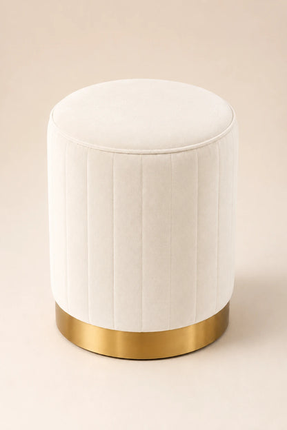 White ottoman with a gold base on a beige background