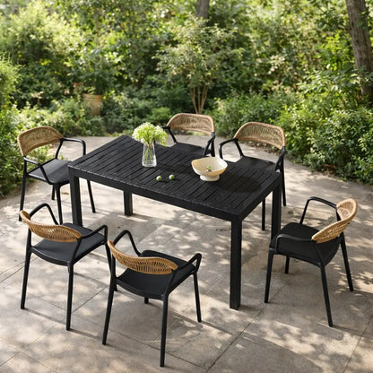 Outdoor dining set with black table and wicker chairs on a patio