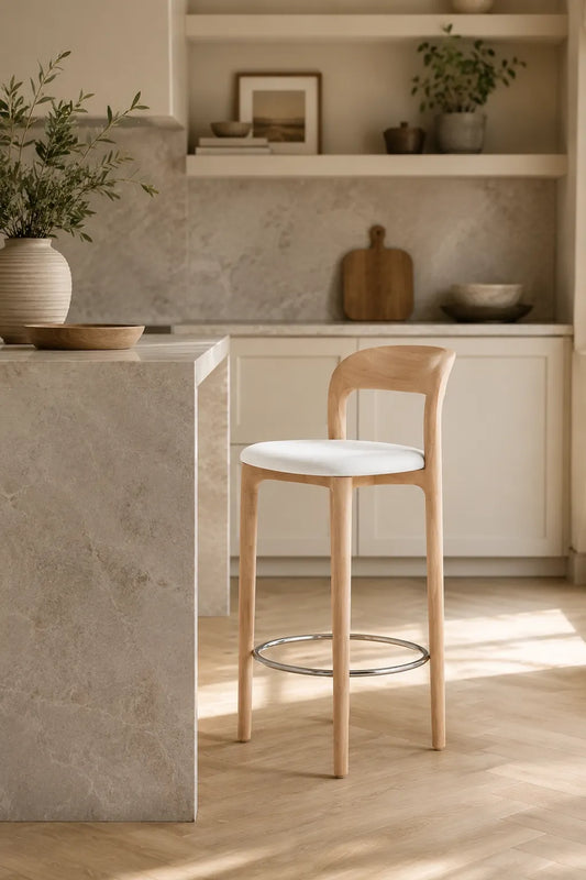 Mid-Century Southwood bar stool with oak-colour ash wood frame, white upholstered seat and chrome footrest in three-quarter studio view