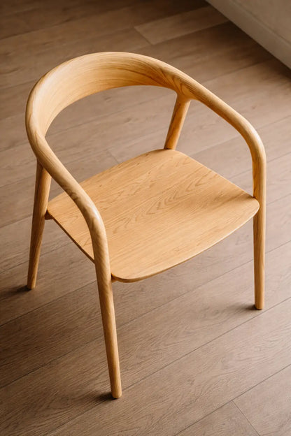 Angled view of a wooden Scandinavian dining chair in a light interior, suitable for café seating and contemporary restaurant dining in the UK.