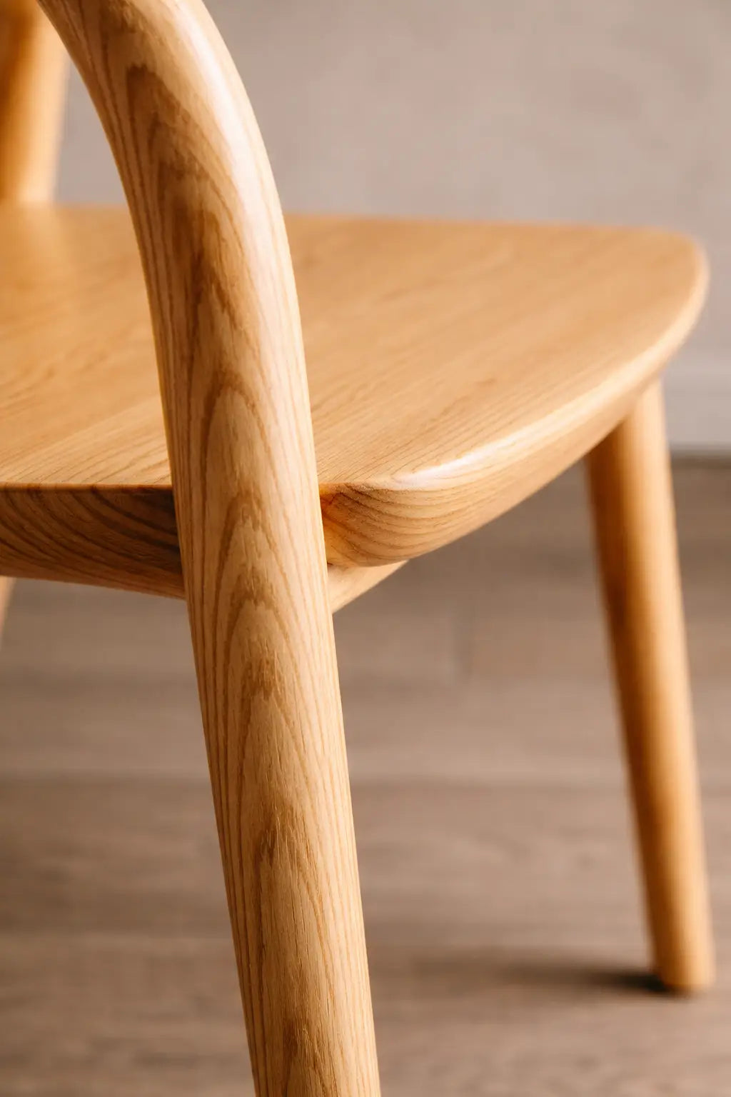 Close-up detail of a natural wood Scandinavian dining chair, showing smooth craftsmanship for durable restaurant dining chair and café seating use.