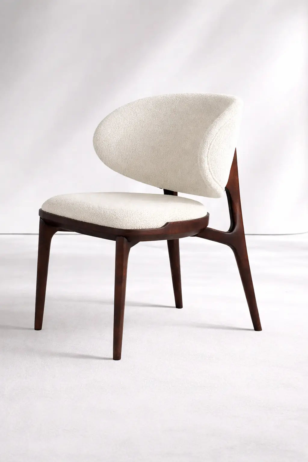 Modern chair with wooden legs and white cushioned seat and backrest on a white background