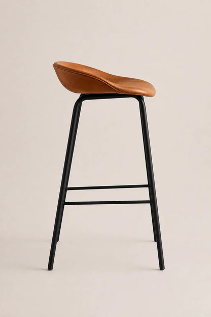 Bar stool with brown seat and black metal legs on a beige background