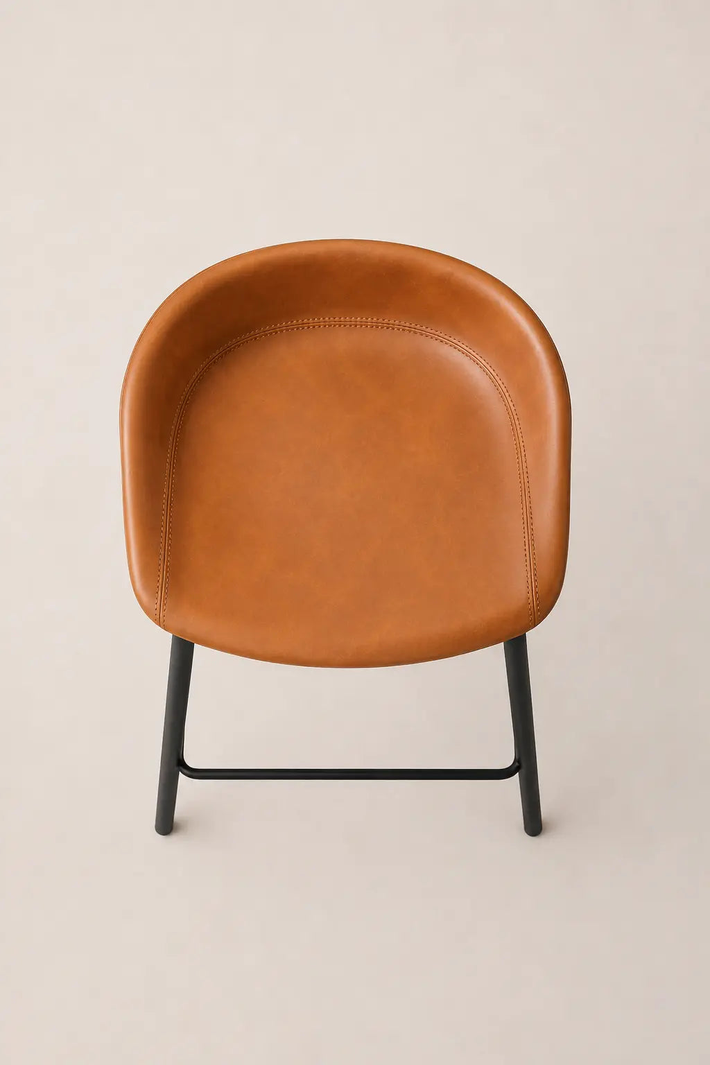 Brown leather chair with black metal legs on a beige background