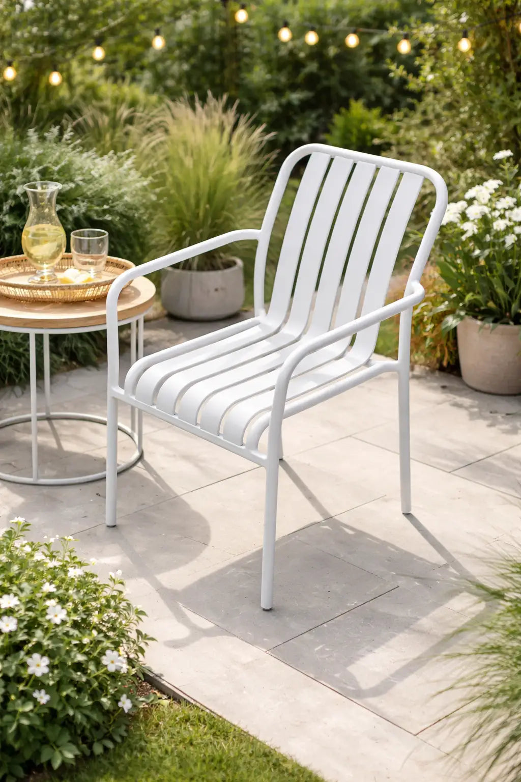 White metal outdoor dining chair with arms styled in a contemporary garden patio
