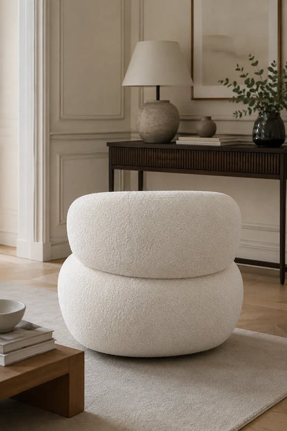 White bouclé armchair back view in a calm reception-style interior with console table