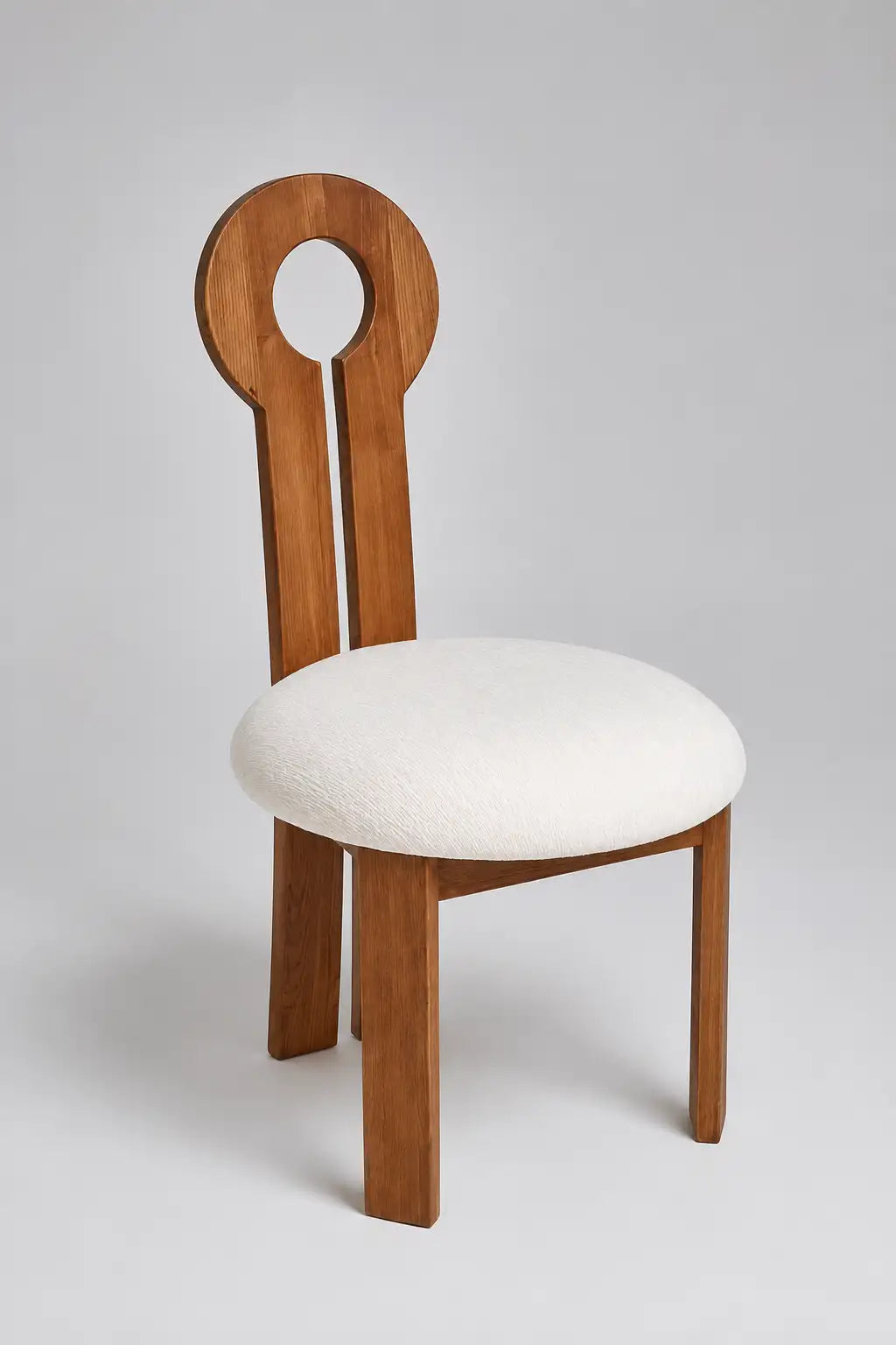 Mid-century key dining chair with sculptural keyhole back, upholstered cream seat and light walnut wood frame, front view