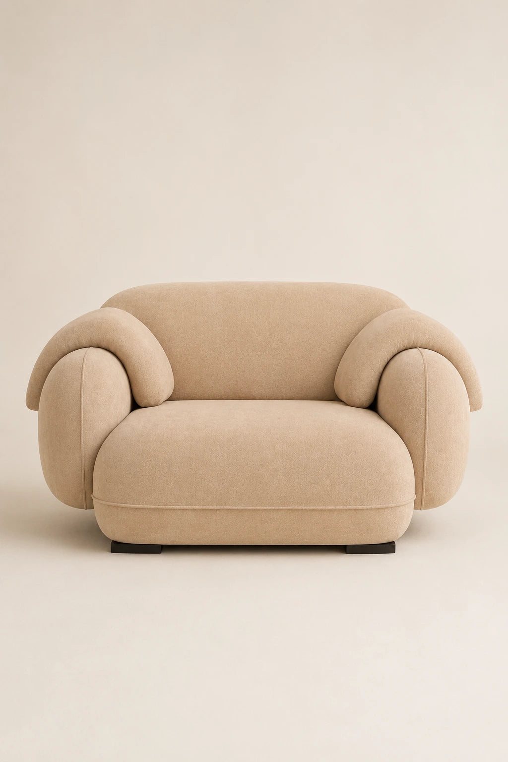 Beige velvet armchair front view with sculptural curved arms and deep seat
