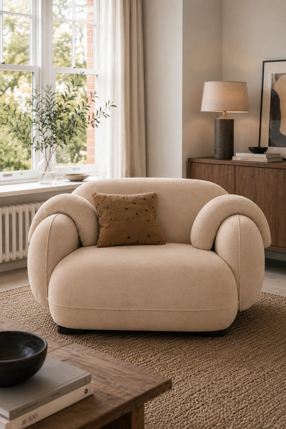 Beige living room armchair styled in a modern interior with soft rug and window light