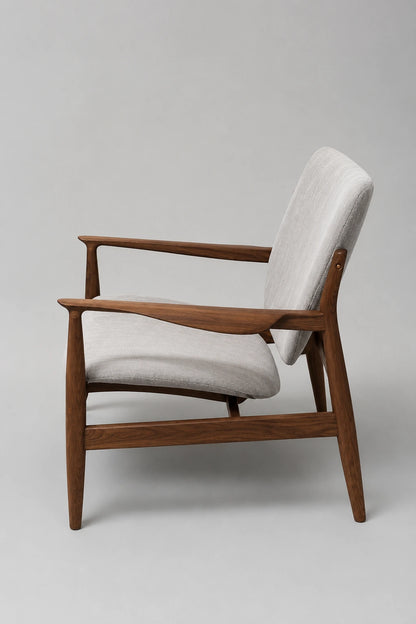 Rear angled view of a walnut mid-century lounge chair with upholstered back and sculpted wooden arms